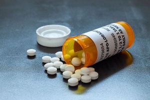 medicine bottle tipped over and open with pills around it