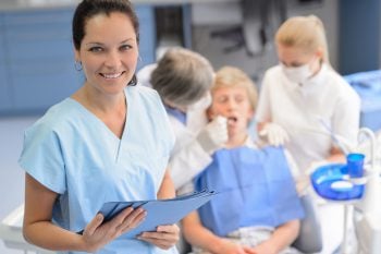 smiling dental staff with person in chair